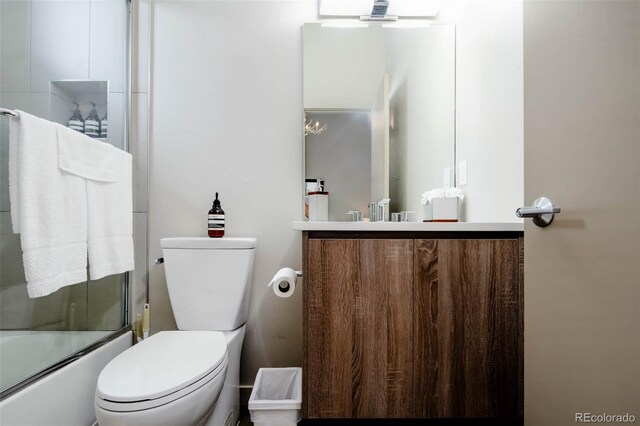 full bathroom featuring vanity, bath / shower combo with glass door, a notable chandelier, and toilet