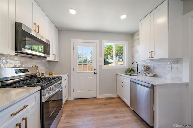 3216 Elizabeth, Denver, CO 80205 - kitchen featuring appliances with stainless steel finishes, recessed lighting, light wood-style floors, white cabinetry, and light countertops