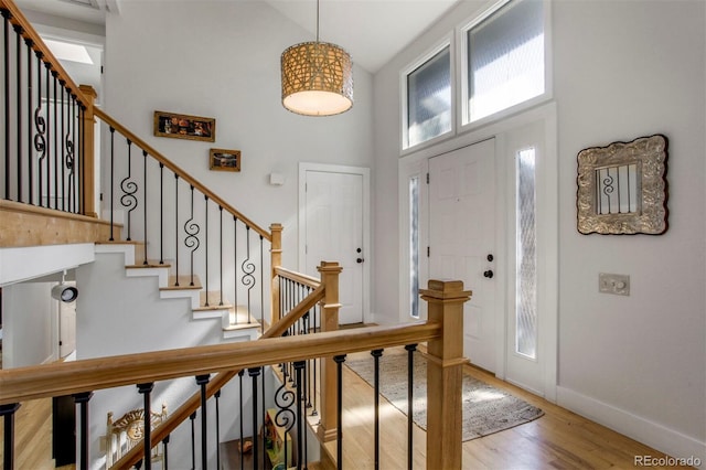 8413 E Jamison Cir, Englewood, CO 80112 - foyer featuring wood finished floors, high vaulted ceiling, and stairway