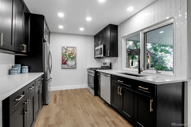 8413 E Jamison Cir, Englewood, CO 80112 - kitchen with stainless steel appliances, dark cabinetry, light wood finished floors, and recessed lighting
