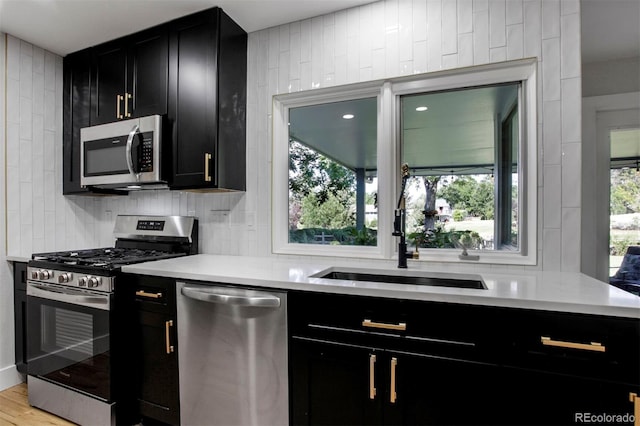 8413 E Jamison Cir, Englewood, CO 80112 - kitchen with appliances with stainless steel finishes, dark cabinets, backsplash, and light countertops