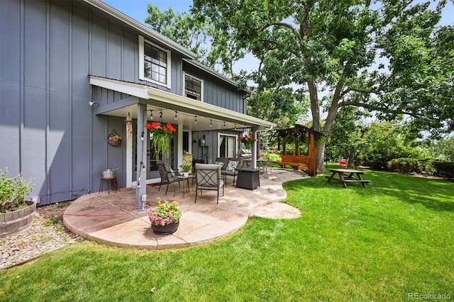 8413 E Jamison Cir, Englewood, CO 80112 - rear view of house featuring a patio, a lawn, and board and batten siding