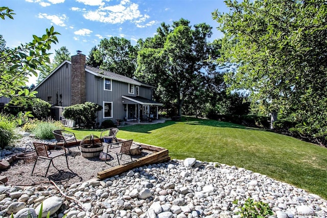 8413 E Jamison Cir, Englewood, CO 80112 - view of grassy yard featuring a fire pit and a patio area
