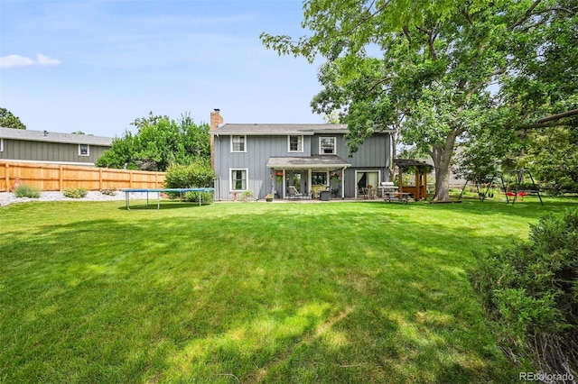 8413 E Jamison Cir, Englewood, CO 80112 - rear view of property featuring a trampoline, a chimney, board and batten siding, and a patio