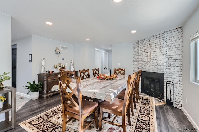 dining room with a fireplace and dark hardwood / wood-style floors