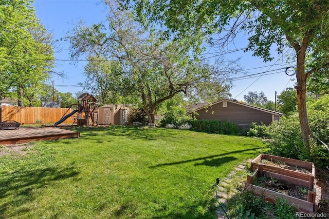 11320 Irma Dr, Northglenn, CO 80233 - view of yard featuring a garden, a wooden deck, and a playground