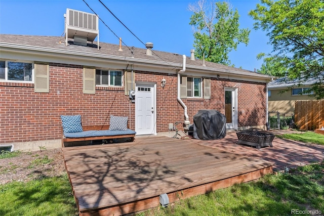 11320 Irma Dr, Northglenn, CO 80233 - back of property featuring a deck, a fire pit, brick siding, and cooling unit