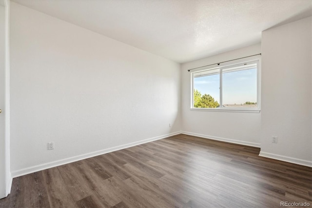 unfurnished room with wood finished floors and baseboards