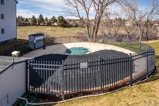 view of swimming pool with a fenced in pool, fence, a lawn, an outdoor structure, and a patio area