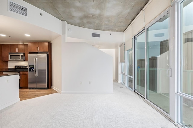 kitchen with stainless steel appliances and light colored carpet