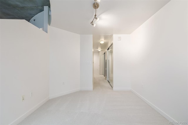 spare room with light carpet and rail lighting