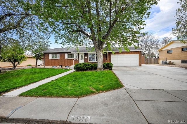 ranch-style house with an attached garage, fence, concrete driveway, a front lawn, and brick siding