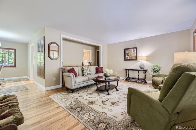 living area with light wood-style flooring and baseboards