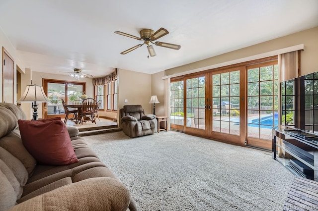living room featuring a healthy amount of sunlight, french doors, ceiling fan, and carpet floors