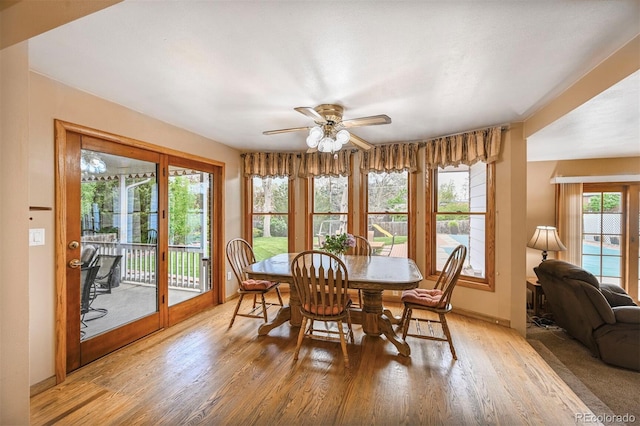 dining room with light wood-style floors, baseboards, and ceiling fan