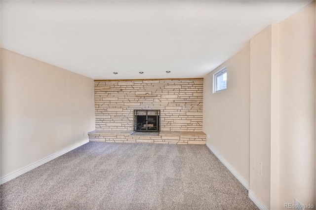 unfurnished living room featuring a fireplace, carpet flooring, and baseboards