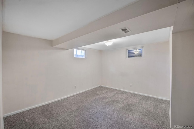 basement featuring baseboards, visible vents, and carpet
