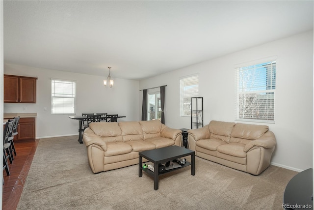 6434 N Ensenada Ct, Aurora, CO 80019 - carpeted living area with baseboards and a chandelier