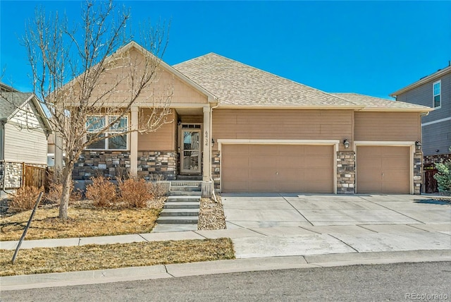 6434 N Ensenada Ct, Aurora, CO 80019 - view of front facade with roof with shingles, an attached garage, driveway, and stone siding