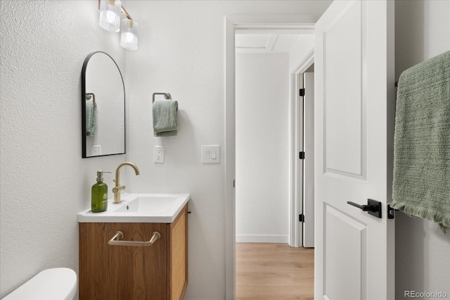 bathroom featuring hardwood / wood-style floors, vanity, and toilet