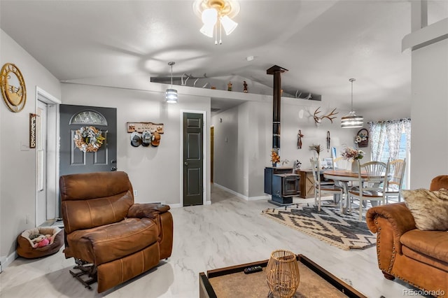 3569 County Road 19, Florence, CO 81226 - living room featuring a wood stove, lofted ceiling, a ceiling fan, baseboards, and marble finish floors