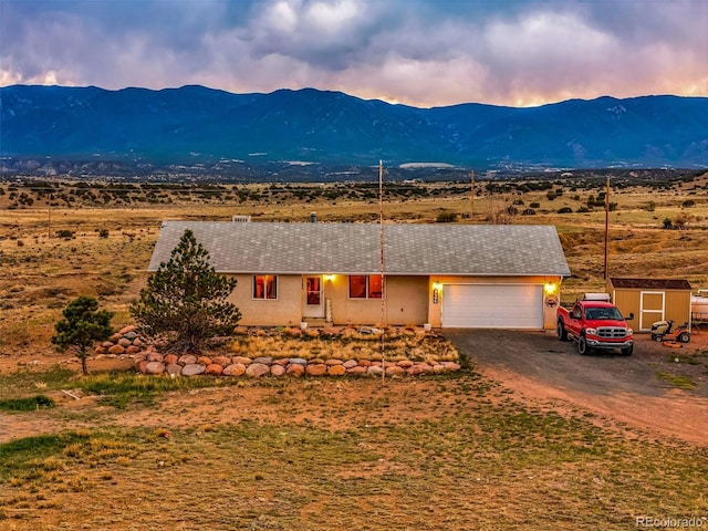 3569 County Road 19, Florence, CO 81226 - single story home featuring a mountain view, driveway, an attached garage, and a shed