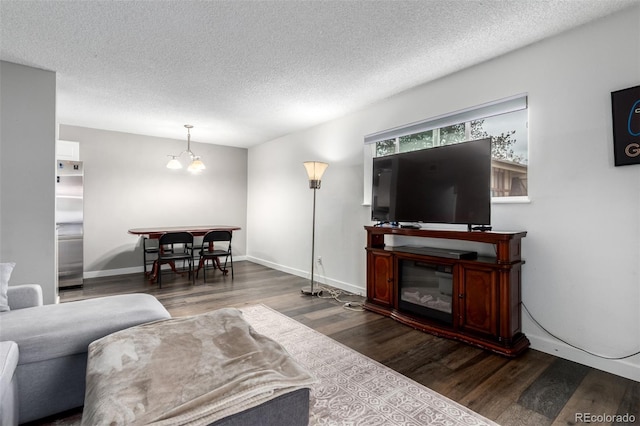 10211 Ura Ln Unit 8-102, Thornton, CO 80260 - living area featuring dark wood-style floors, a textured ceiling, and a glass covered fireplace