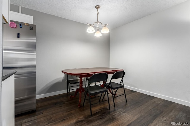 10211 Ura Ln Unit 8-102, Thornton, CO 80260 - dining space featuring dark wood finished floors, a textured ceiling, and a chandelier