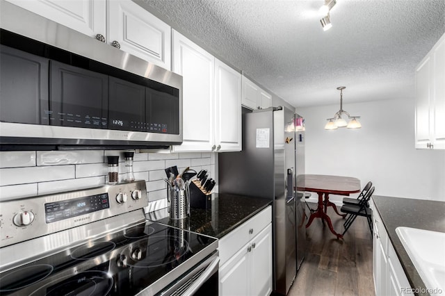 10211 Ura Ln Unit 8-102, Thornton, CO 80260 - kitchen featuring stainless steel appliances, a textured ceiling, wood finished floors, backsplash, and white cabinetry