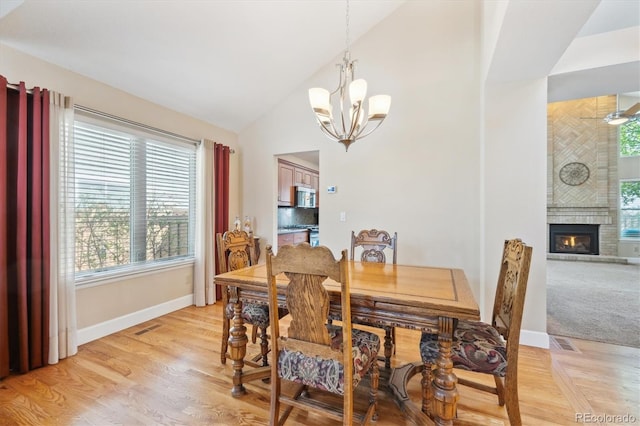 dining space with baseboards, a notable chandelier, visible vents, and a fireplace