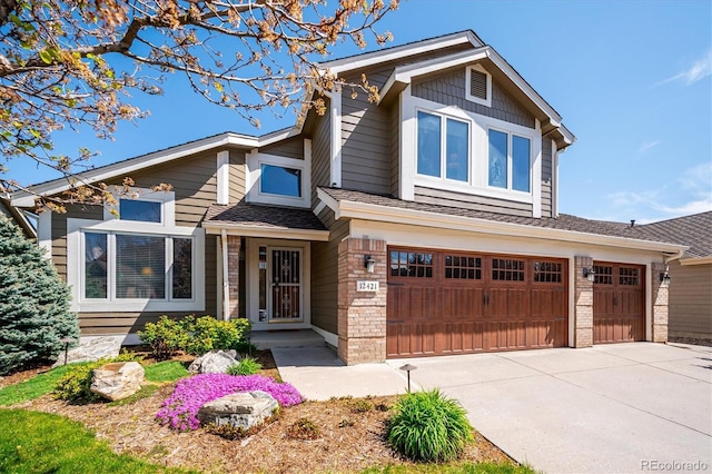 craftsman-style house with brick siding, an attached garage, roof with shingles, and driveway