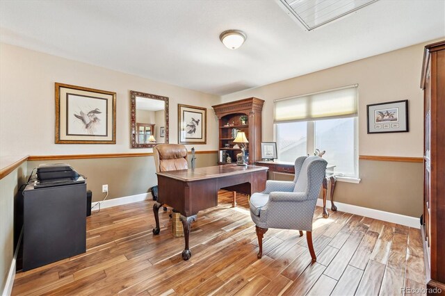 office space featuring baseboards and light wood-style floors