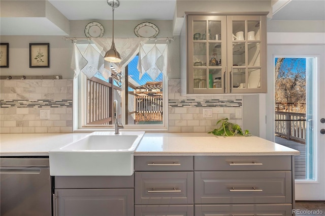 kitchen with sink, gray cabinets, backsplash, decorative light fixtures, and stainless steel dishwasher