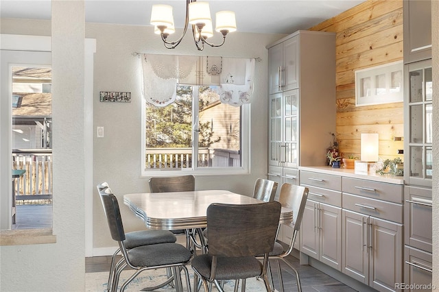 dining space featuring a notable chandelier and wood walls