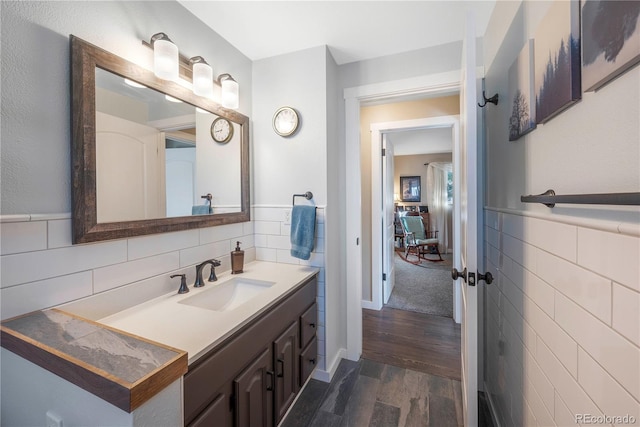 bathroom featuring hardwood / wood-style flooring, vanity, and tile walls