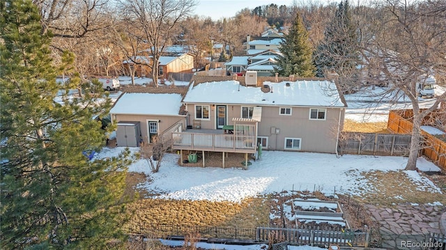 snow covered house featuring a wooden deck