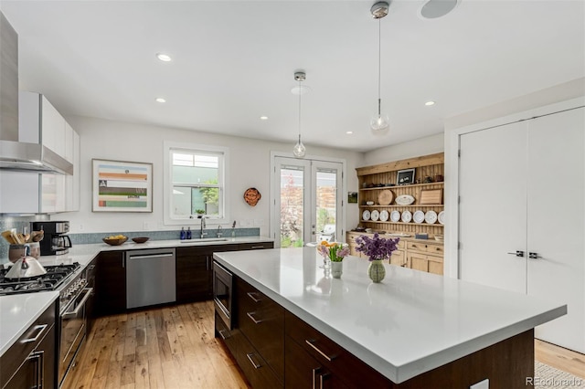 3168 W 29th Ave, Denver, CO 80211 - kitchen featuring stainless steel appliances, wall chimney range hood, a sink, light countertops, and modern cabinets