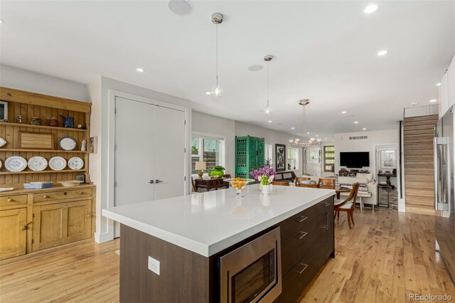 3168 W 29th Ave, Denver, CO 80211 - kitchen featuring stainless steel microwave, light wood-style floors, light countertops, recessed lighting, and a center island