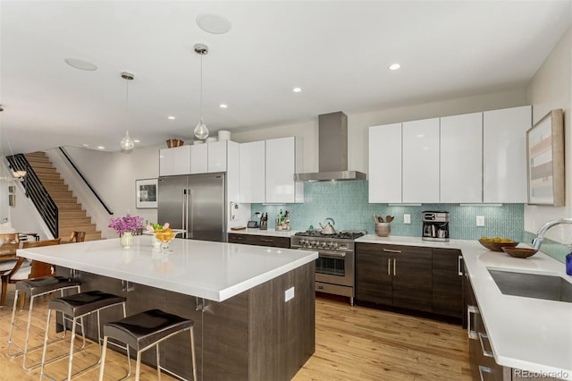 3168 W 29th Ave, Denver, CO 80211 - kitchen with high quality appliances, wall chimney exhaust hood, a kitchen breakfast bar, a sink, and a center island