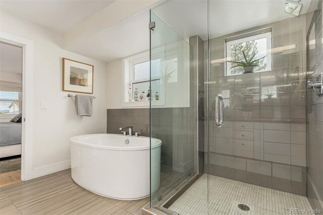 3168 W 29th Ave, Denver, CO 80211 - bathroom featuring a soaking tub, a shower stall, wood finished floors, and baseboards