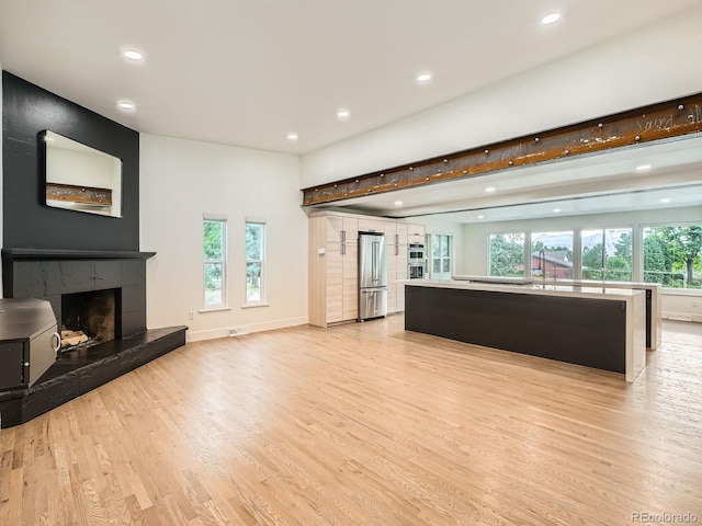 22 Rangeview Dr, Wheat Ridge, CO 80215 - unfurnished living room featuring recessed lighting, light wood finished floors, and a tiled fireplace