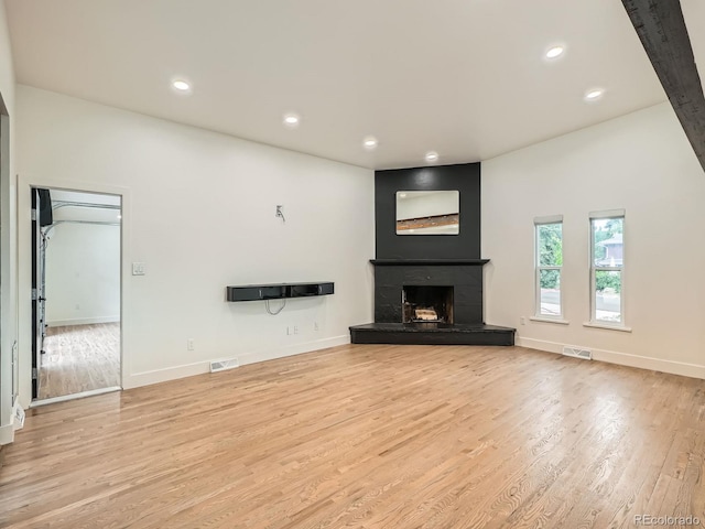 22 Rangeview Dr, Wheat Ridge, CO 80215 - unfurnished living room with wood finished floors, a fireplace with raised hearth, and recessed lighting