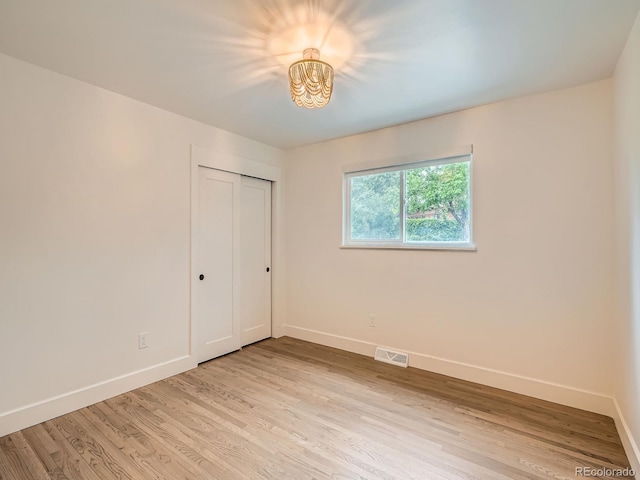 22 Rangeview Dr, Wheat Ridge, CO 80215 - unfurnished bedroom with light wood-style floors, a chandelier, and a closet