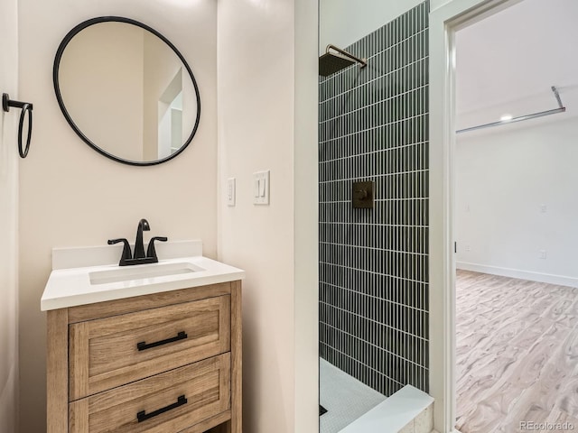 22 Rangeview Dr, Wheat Ridge, CO 80215 - bathroom featuring a tile shower, vanity, and wood finished floors