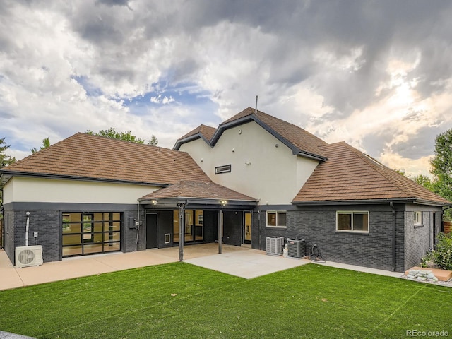 22 Rangeview Dr, Wheat Ridge, CO 80215 - rear view of house featuring a lawn, brick siding, stucco siding, and a patio area