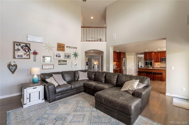 2339 Elkhorn St, Parker, CO 80138 - living area with wood finished floors, baseboards, arched walkways, a towering ceiling, and recessed lighting
