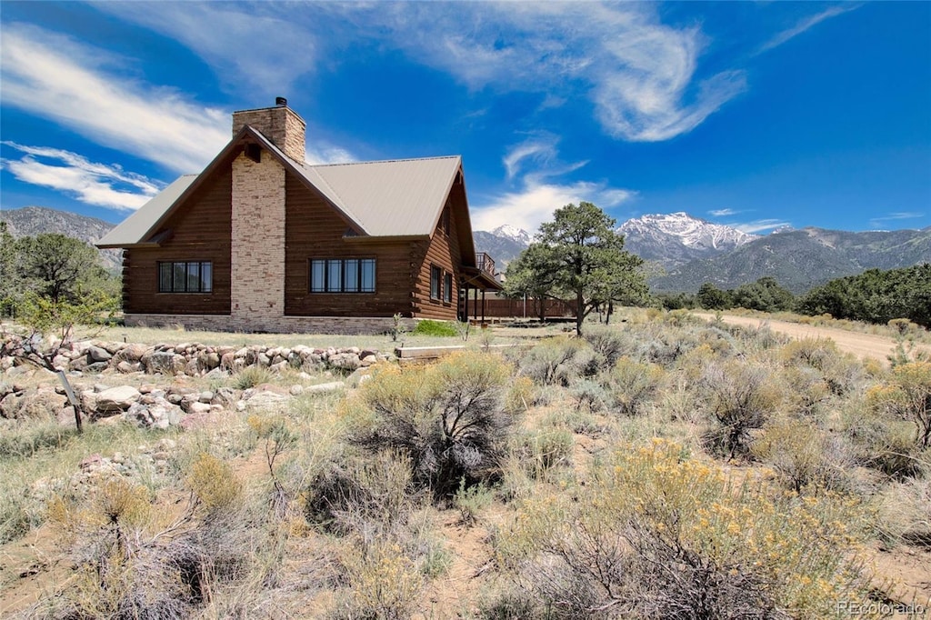 637 Panorama Way, Crestone, CO 81131 - view of side of property featuring a chimney, a mountain view, and log exterior