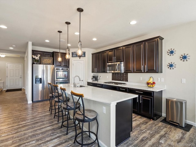353 Zuniga St, Brighton, CO 80601 - kitchen with a sink, dark wood finished floors, appliances with stainless steel finishes, and a kitchen breakfast bar