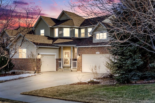 view of front of property with driveway, a shingled roof, a garage, and brick siding