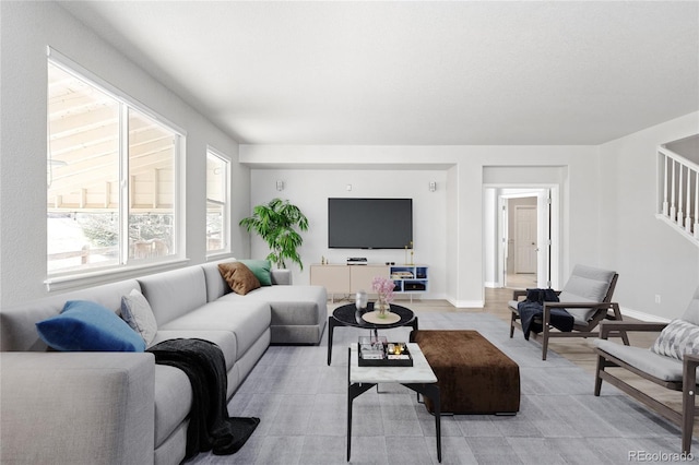 living area with stairs and baseboards